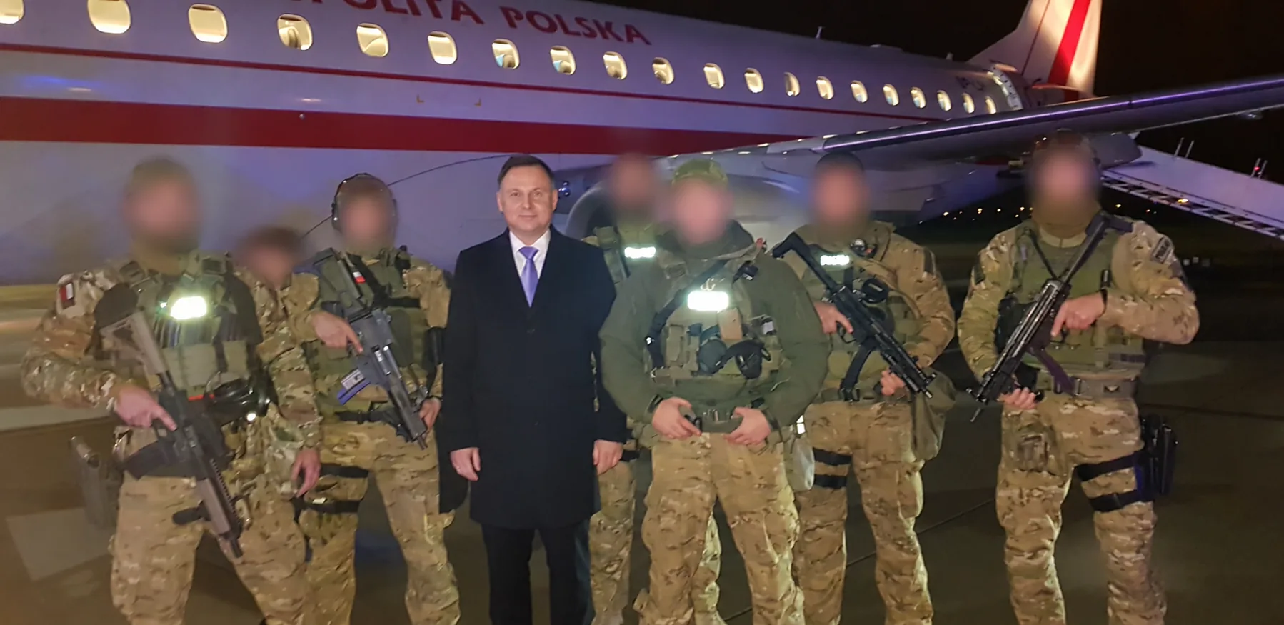 Archiwalne zdjęcie grupowe przy samolocie; twarze operatorów zamazane