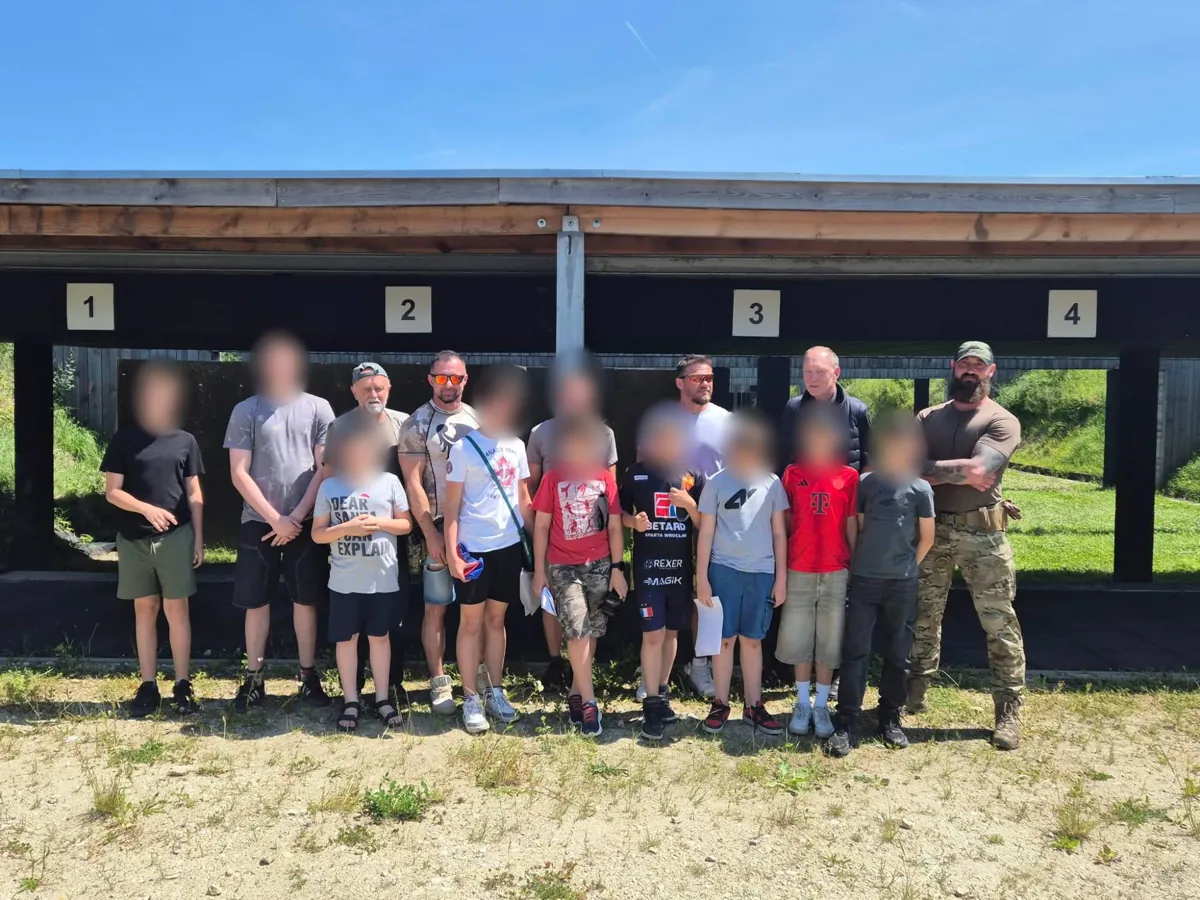 Gruppe mit Instruktoren an den überdachten Schießständen von ASC Domaniów